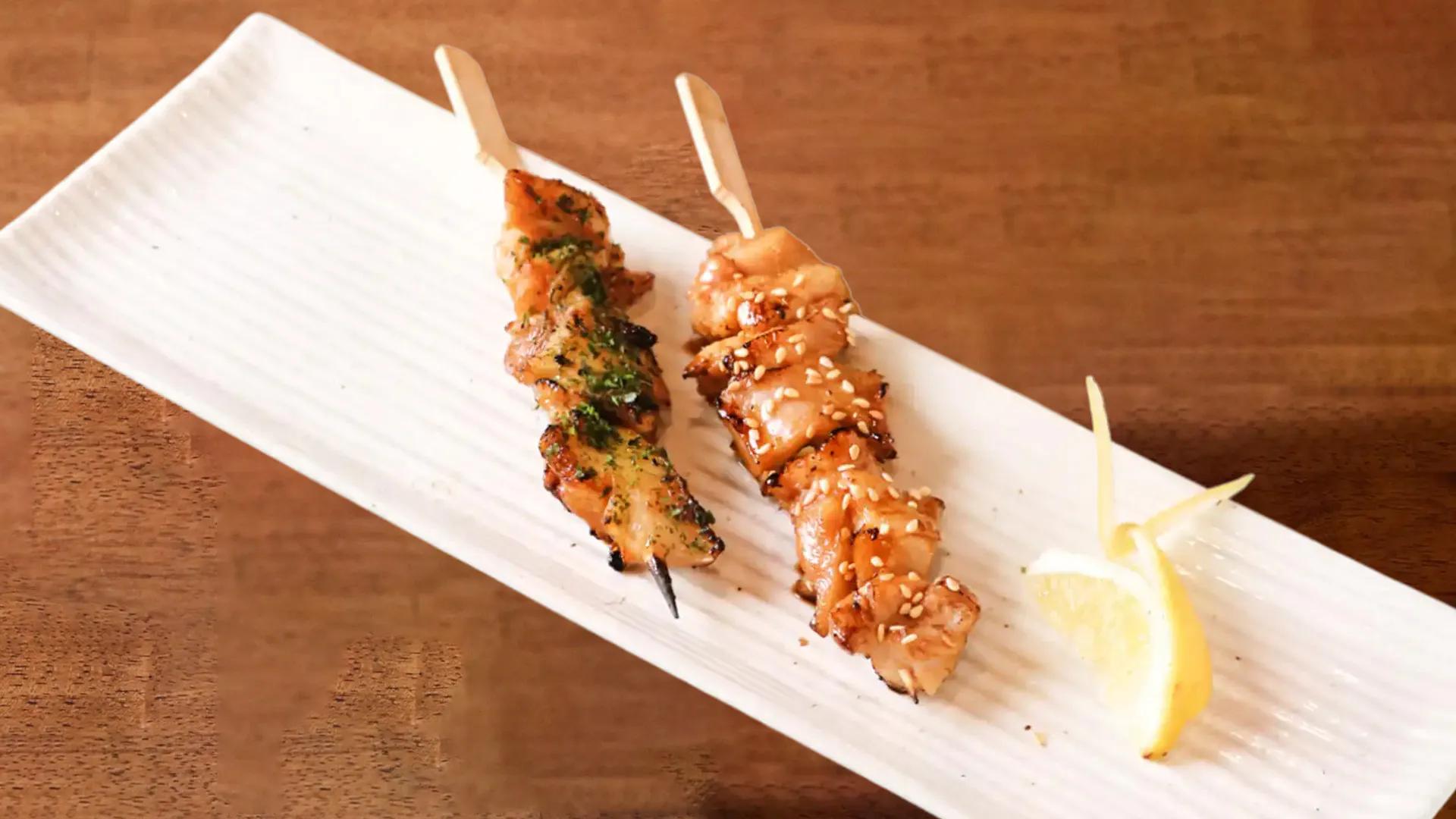 Grilled chicken skewers with sesame, herbs and lemon wedge at Fujiya Ramen & Yakitori, a Asian Restaurant in Arcadia
