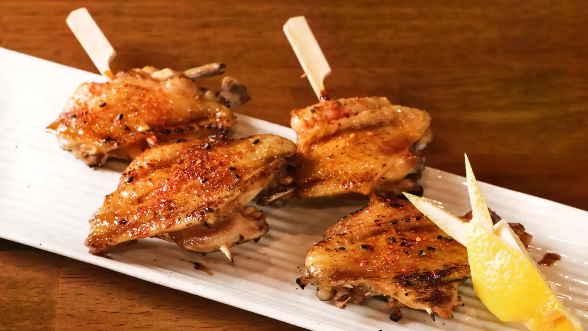 Spicy glazed grilled chicken wing skewers with lemon at Fujiya Ramen & Yakitori, a Asian Restaurant in Arcadia